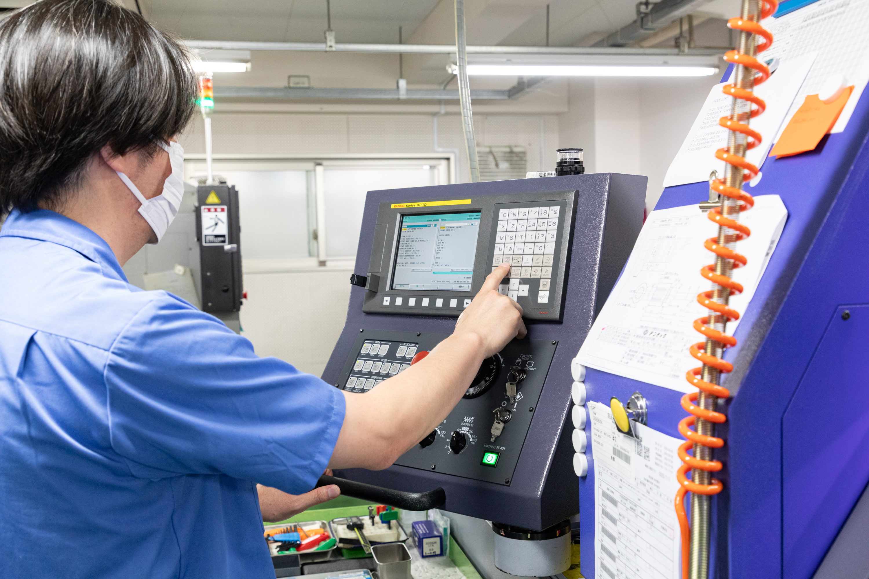 若手社員が高精度NC工作機械を操作する